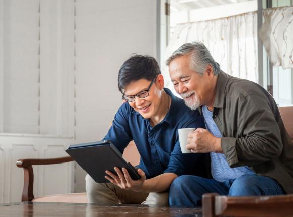 A father and son looking at a tablet