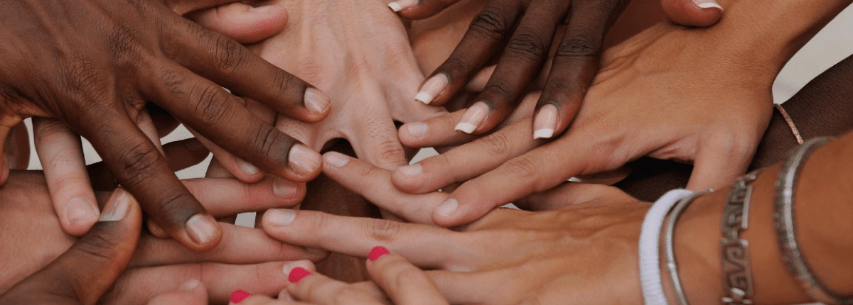 Group of arms extended and hands meeting in centre