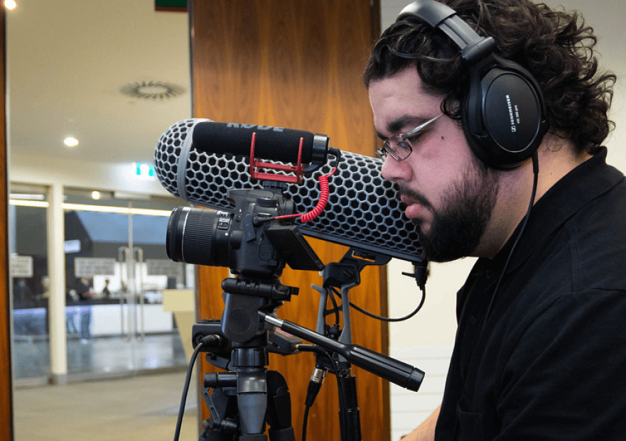 Sebastian Correa looking into his camera view finder while filming