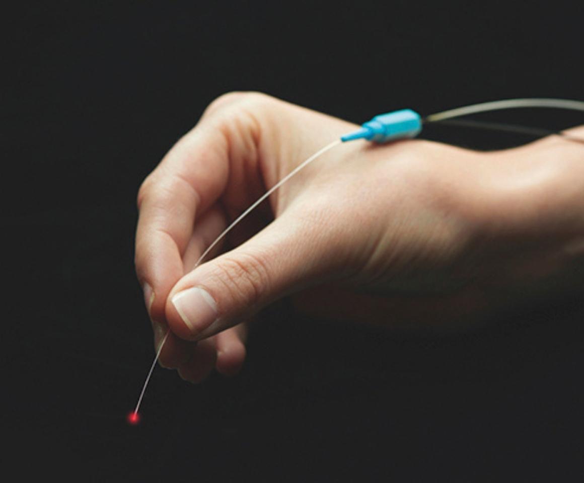 Close up of hand holding a micro-catheter device