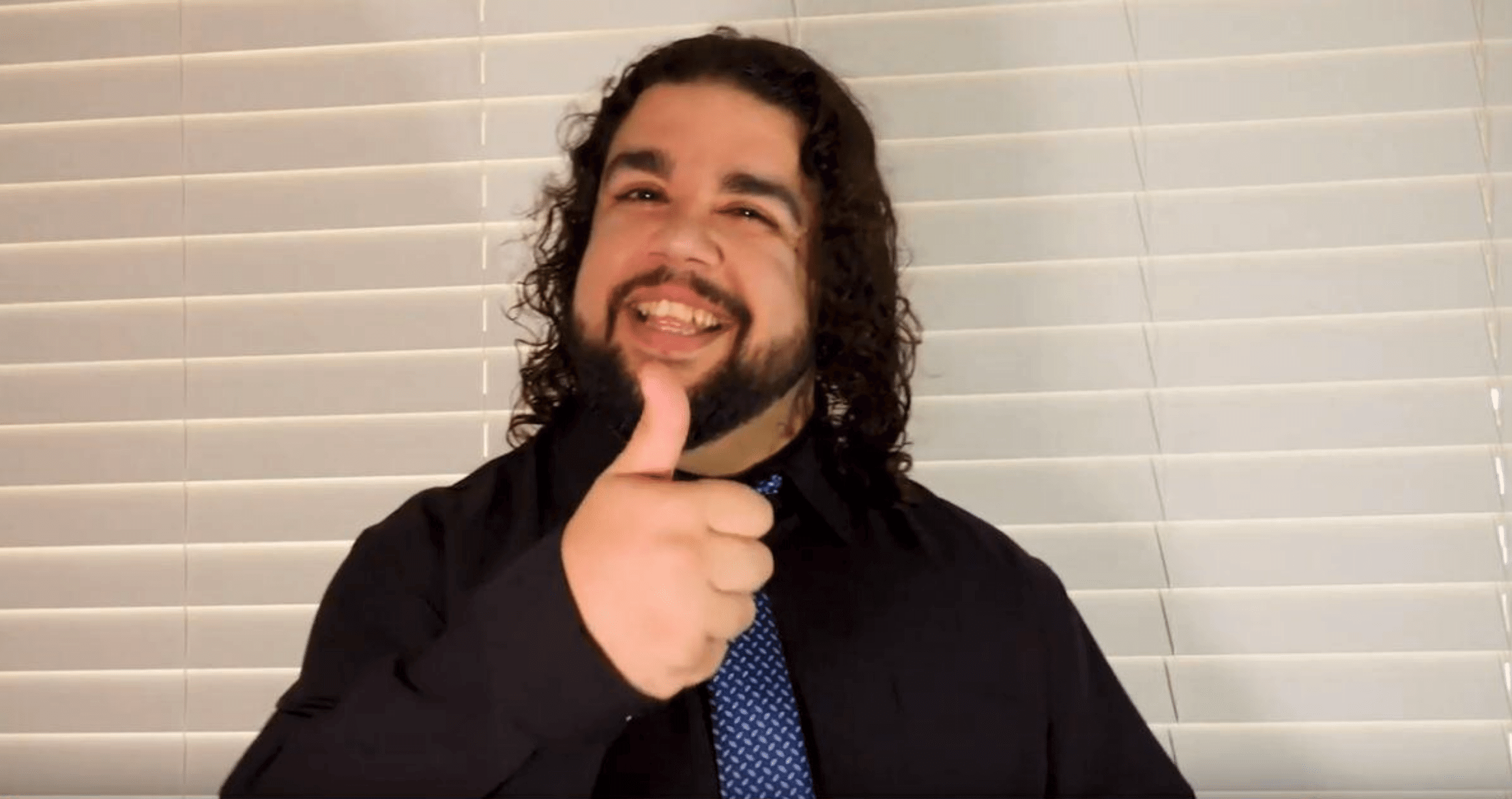 Young man smiling with thumbs up gesture