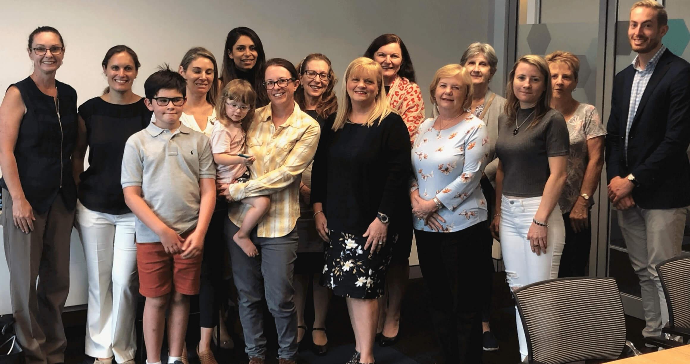 image of diverse group of people in a board room standing and smiling together