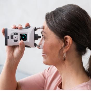 Image of woman in pink t-shirt and long dark pony tail holding up self-tonometry device to her eyes