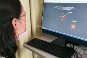 Volunteer at home showing software on computer screen